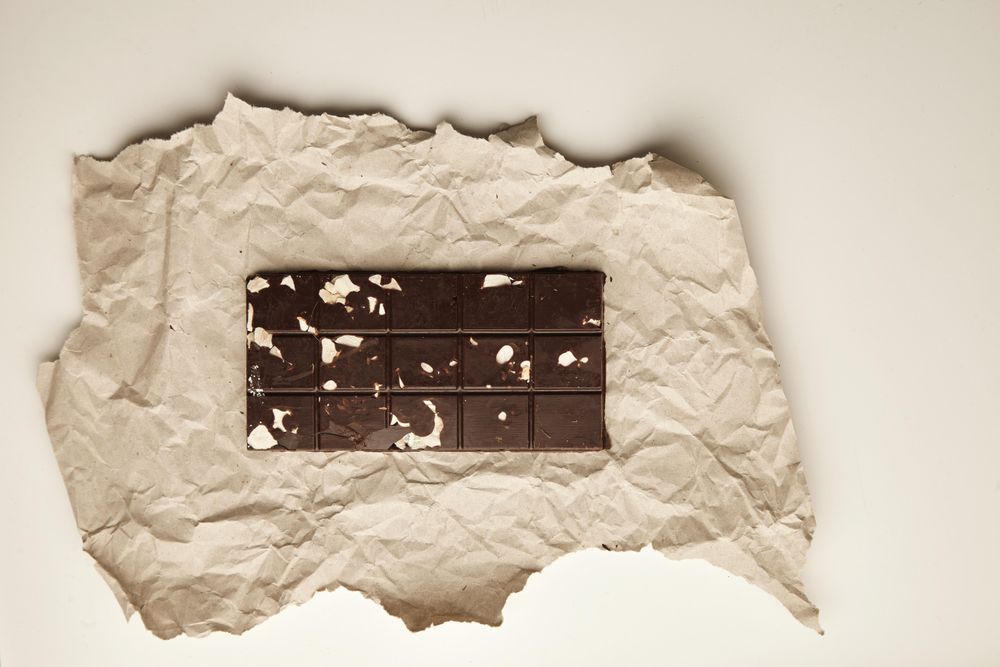 Top view of chocolate bar with almonds on table