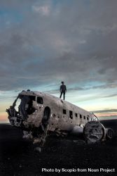 Man standing on wrecked airplane in the middle of nowhere 5lrrob