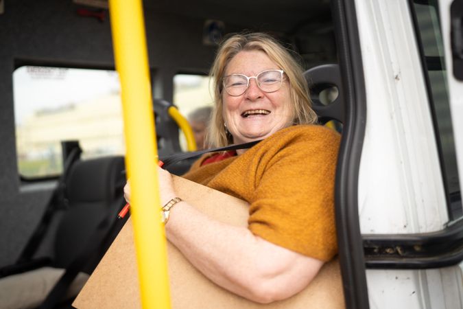 Smiling woman on bus with art supplies