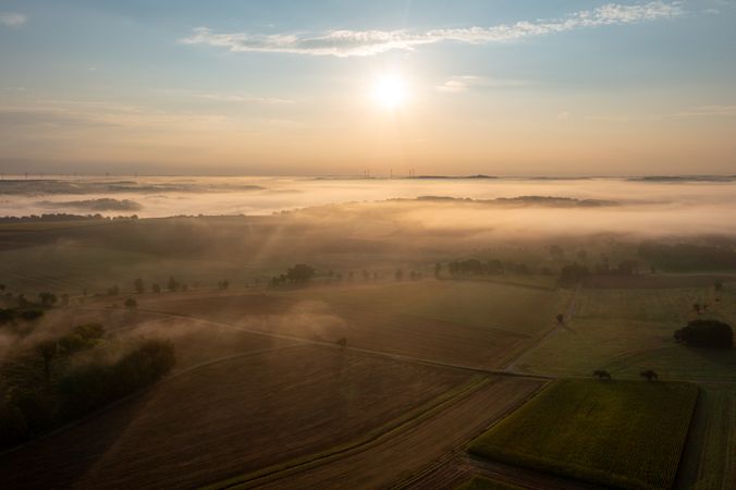 Aerial view in the morning with foggy agricultural fields at golden hour