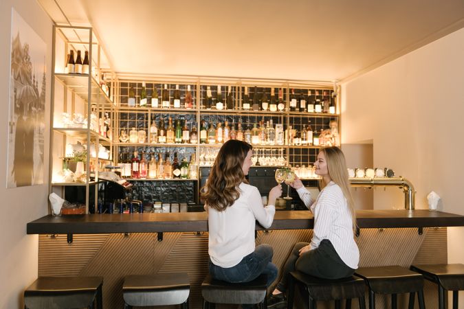 Cheerful women drinking cocktails in bar