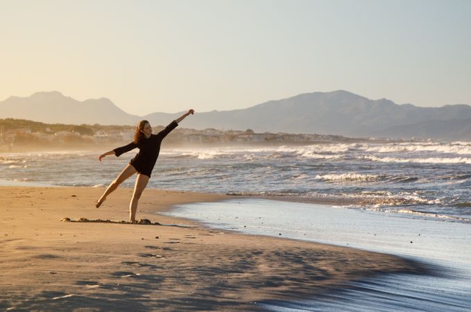 Woman with dancing near water on shore