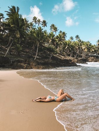 Woman in blue bikini lying on beach during daytime