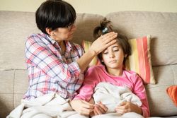 Woman sitting with her sick daughter