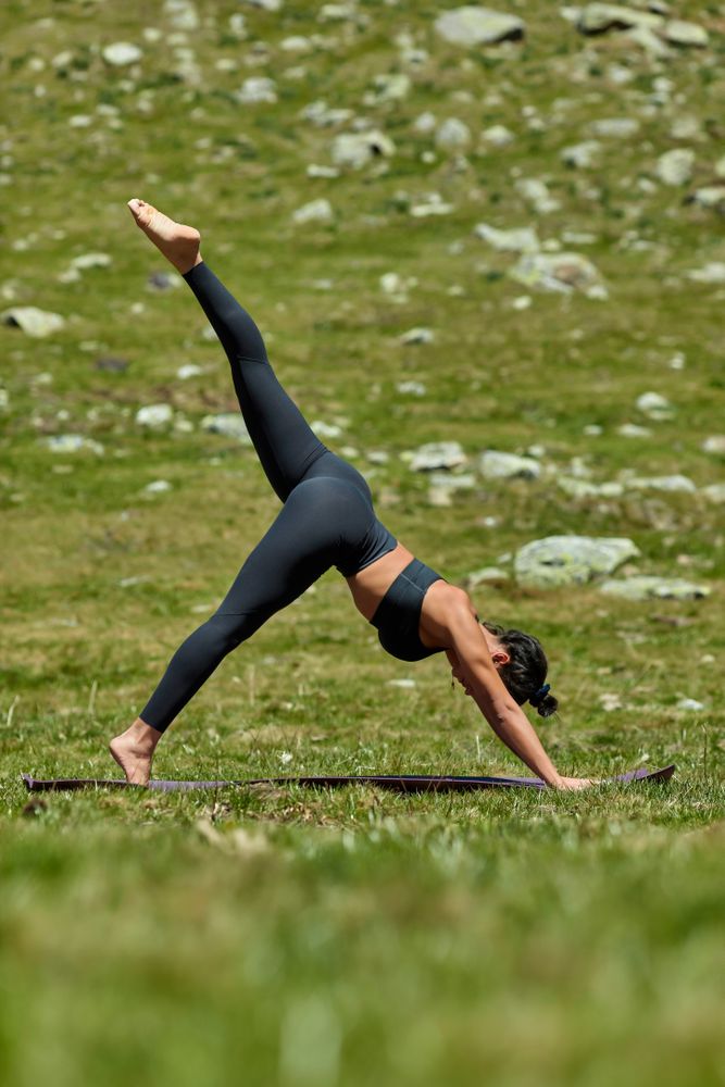 Woman doing three-legged downward dog yoga pose