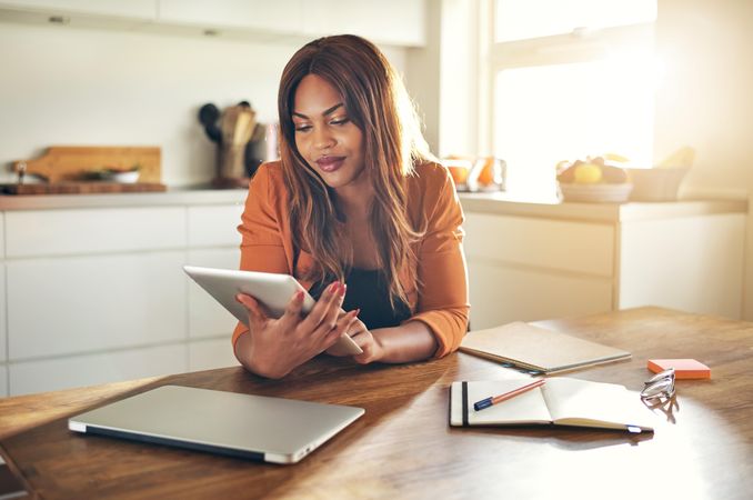 Businesswoman working from home with notebooks and tablet