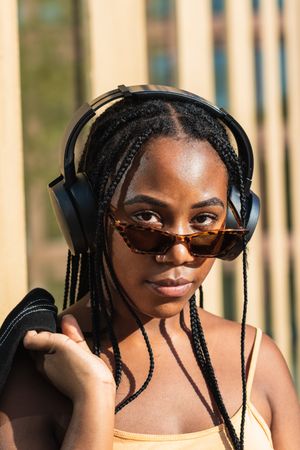 female listening to music outside modern building