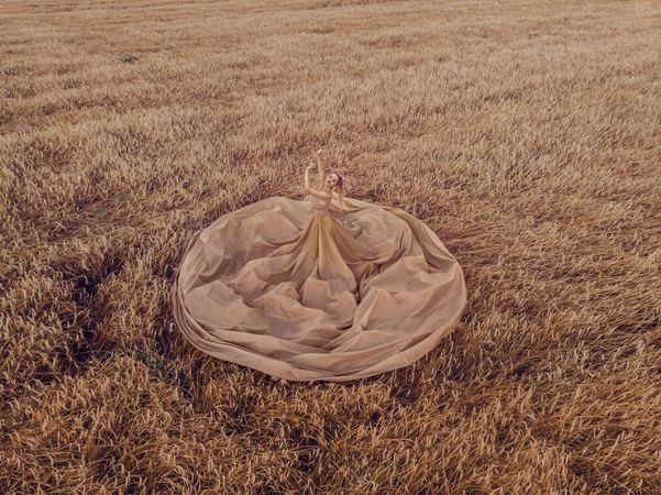 High-angle view of woman in big brown dress in wheat field