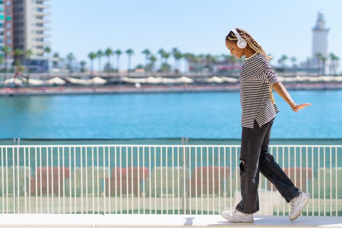 Female on one leg near on walkway beautiful blue water