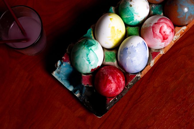 Set of painted Easter eggs in container on table