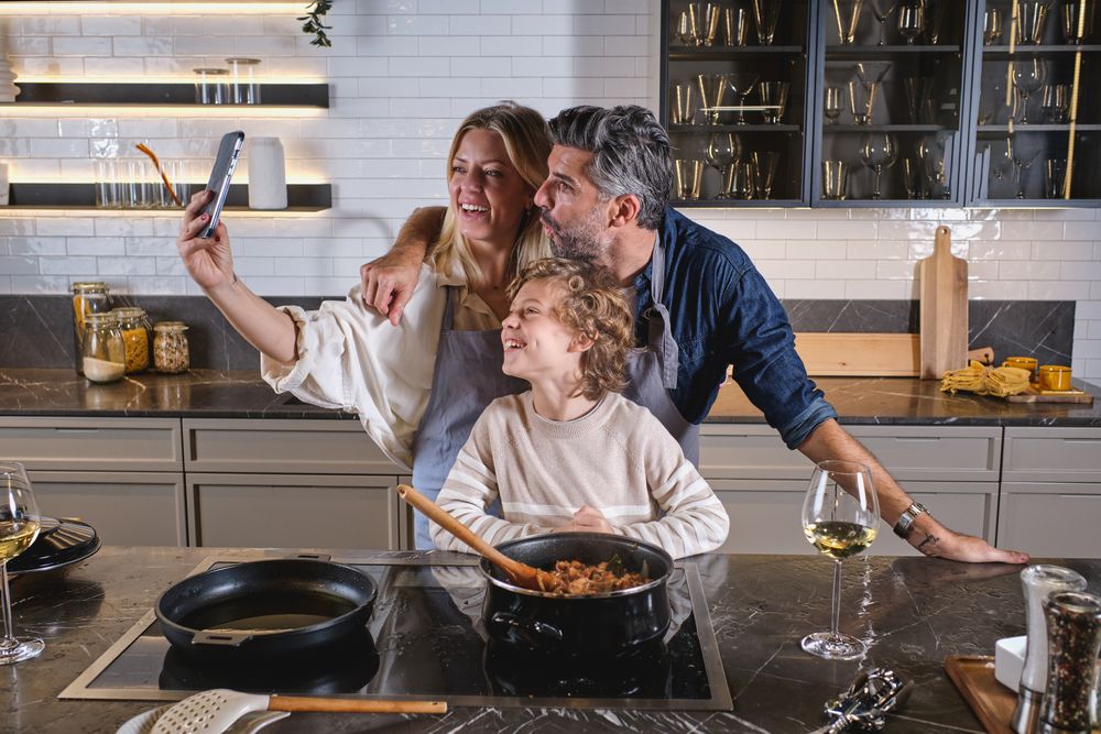 Happy multiethnic family taking selfie in kitchen