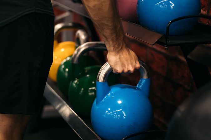 hand of a man taking a kettlebell