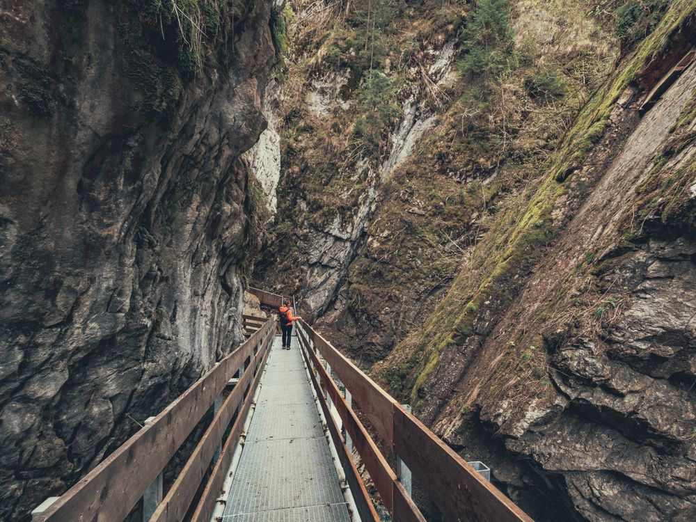 Tourist on hiking path among rocky slopes