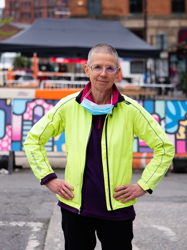 Older woman with hands on hips in neon wind breaker