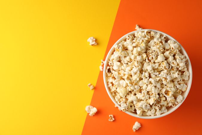 Flat lay composition. Bucket with popcorn on two tone background