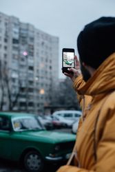 Man taking photo of vehicle on an overcast day