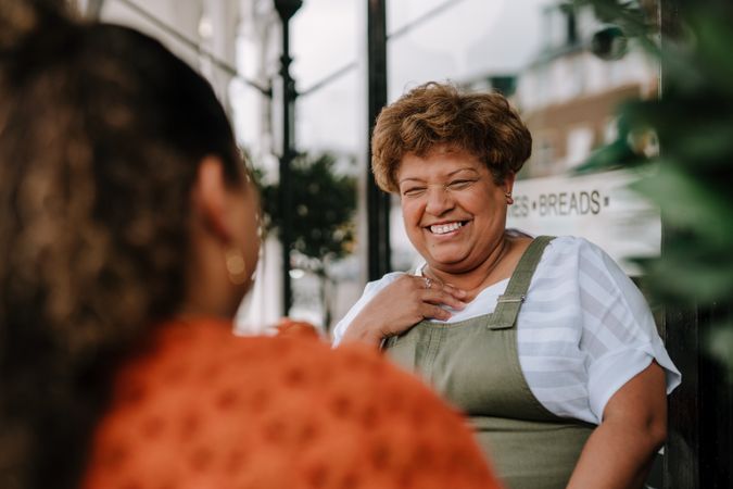 Older Black woman smiling at outdoor table