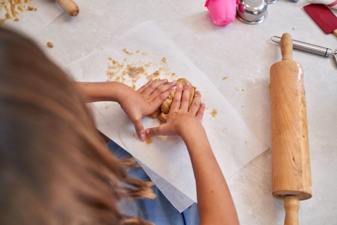 Unrecognizable kid kneading cookie dough