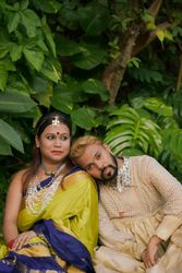 Man leaning on woman's shoulder sitting beside trees in a garden 4M7ak0