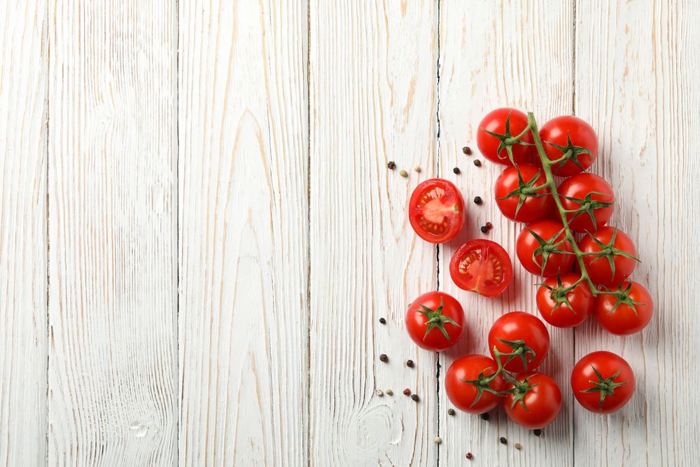 Tomatoes and pepper on wooden background, top view