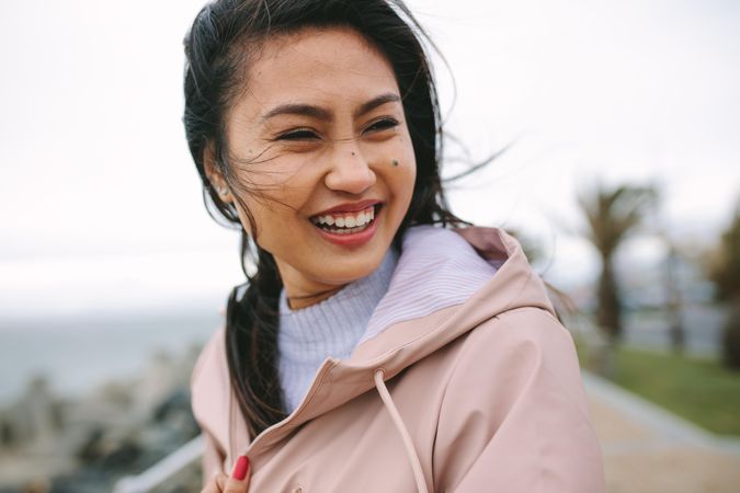 Close-up of young Asian woman smiling in jacket