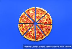 Above view with a delicious pepperoni pizza isolated on a blue background 48wGR5