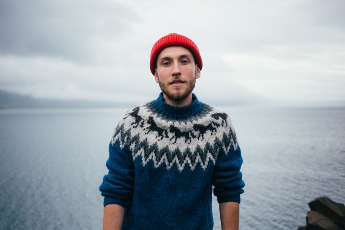 Portrait of man in wool sweater on rugged Icelandic coast