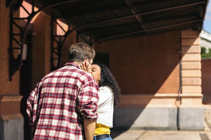 Young couple kissing at the station after a trip