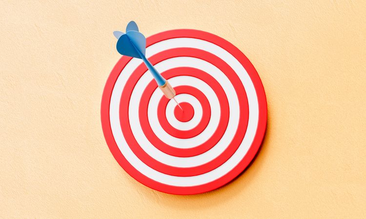 Bullseye with dart in center on pastel background