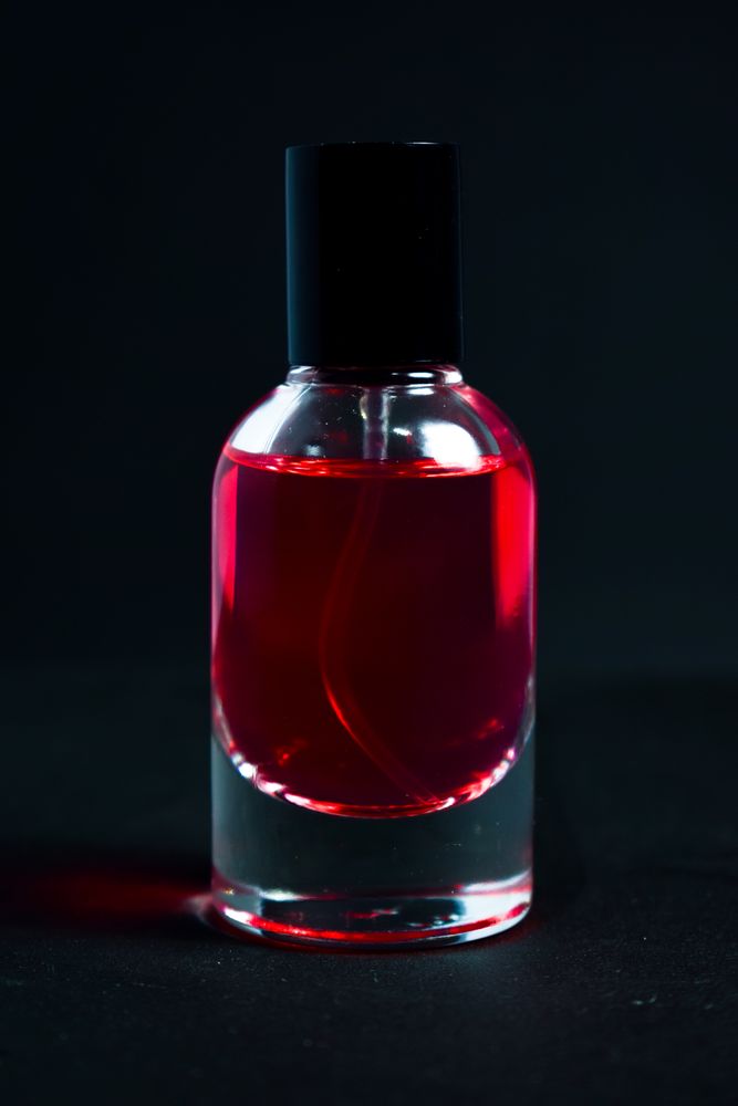 Red perfume bottle in dark studio