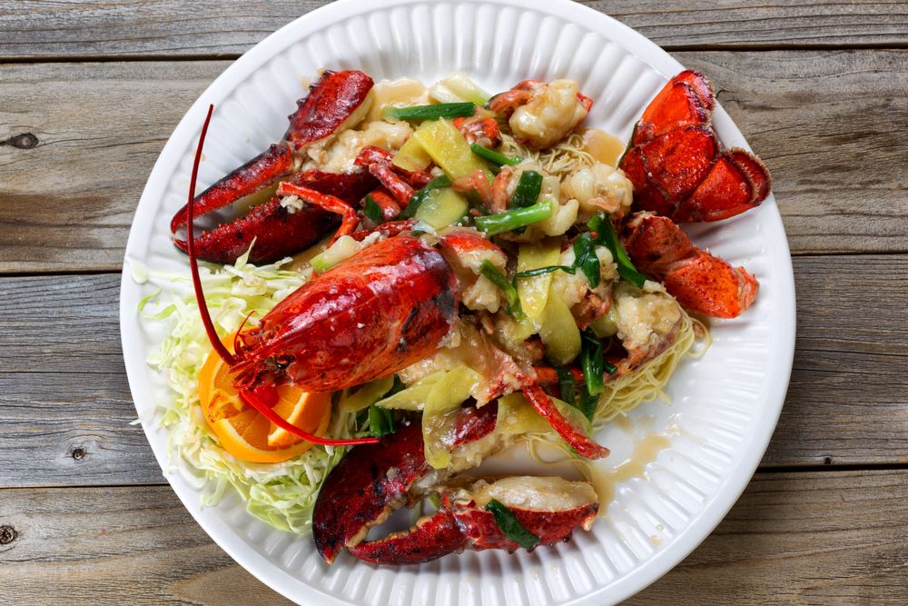 Steamed whole lobster and garnishes on serving plate ready to eat