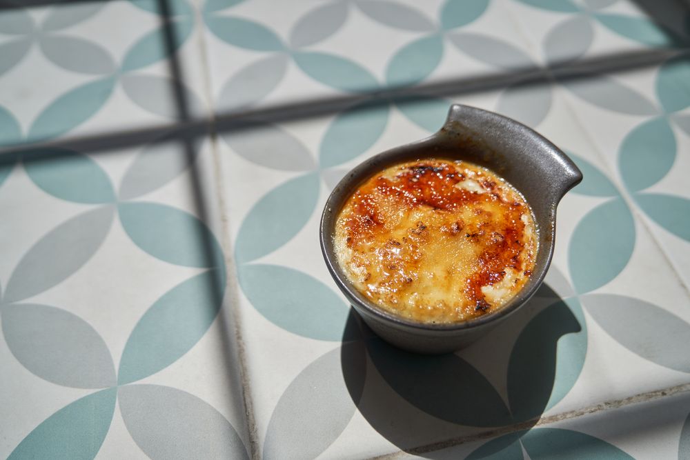 Cup of delicious dessert in bowl on floor
