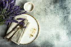 Top view of table setting with bunch of lavender and silverware with space for text