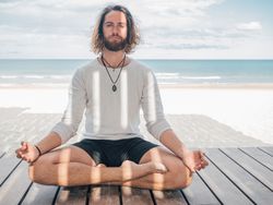 Man meditating on beach