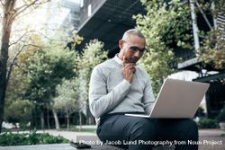 Entrepreneur concentrating on work sitting outdoors 5ond80