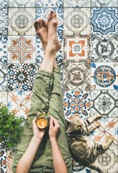 Woman on tiled terrace with coffee and cat