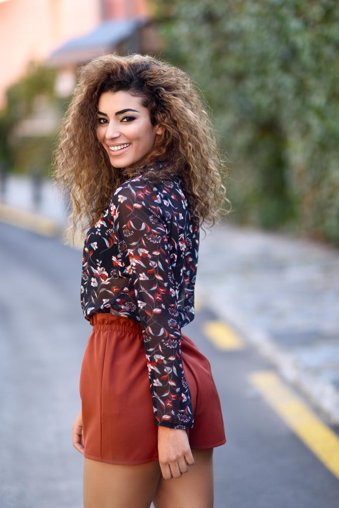 Arab woman looking back while wearing casual clothes in the street