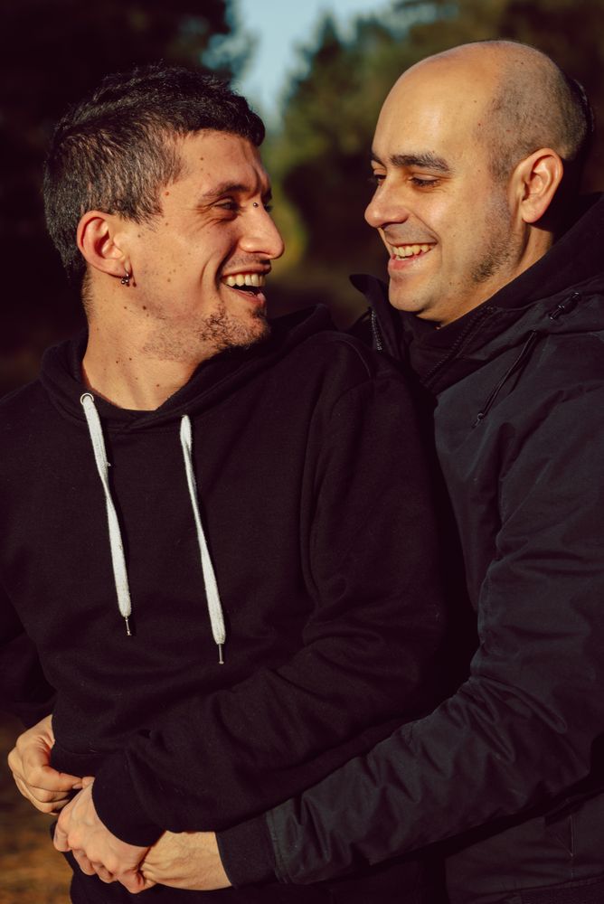 Smiling men hugging on path in park