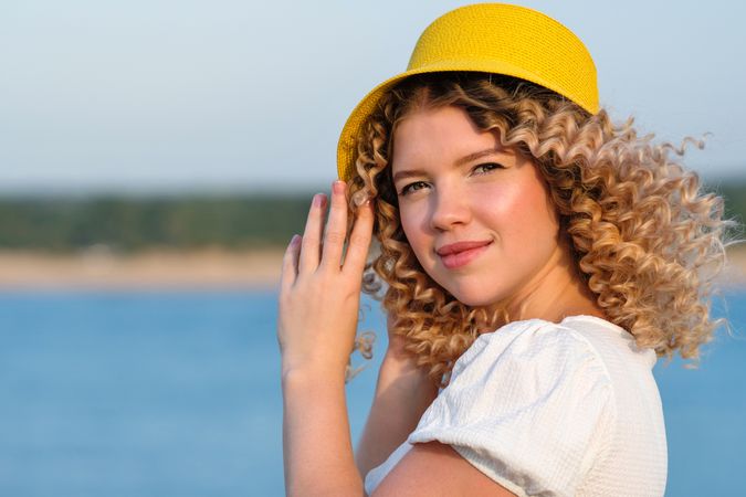 Portrait content woman in yellow hat in windy outdoors