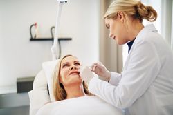 Blonde dermatologist injecting botox treatment