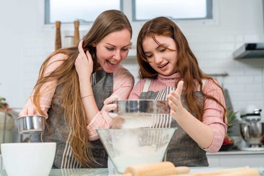 Woman and girl sieving flour