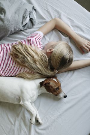 Girl and dog napping back to back