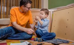 Father and son assembling a new furniture for home