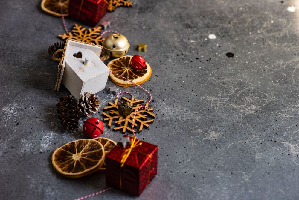 Top view of wooden ornaments, dried orange slices and pine cones on marble table