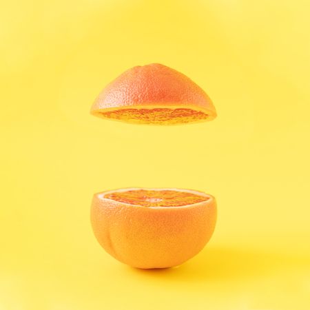 Sliced red grapefruit on bright yellow background