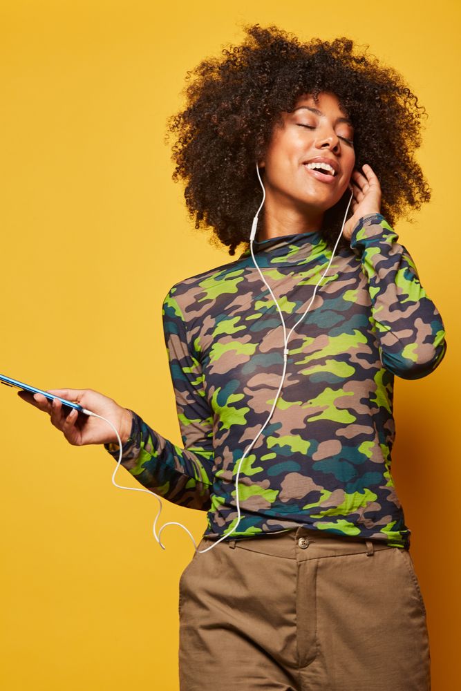 Trendy Black woman with smartphone listening music