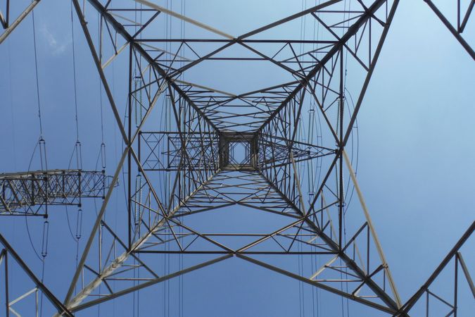 Looking Straight Up Through an Electrical Transmission Tower Against a Clear Sky