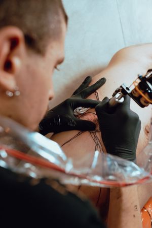 man drawing tattoo