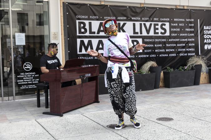 Woman performing with a man accompanying on the piano at a BLM event, Washington, D.C.