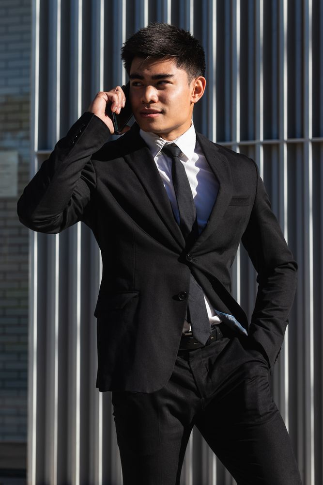 Smiling businessman speaking on smartphone in downtown